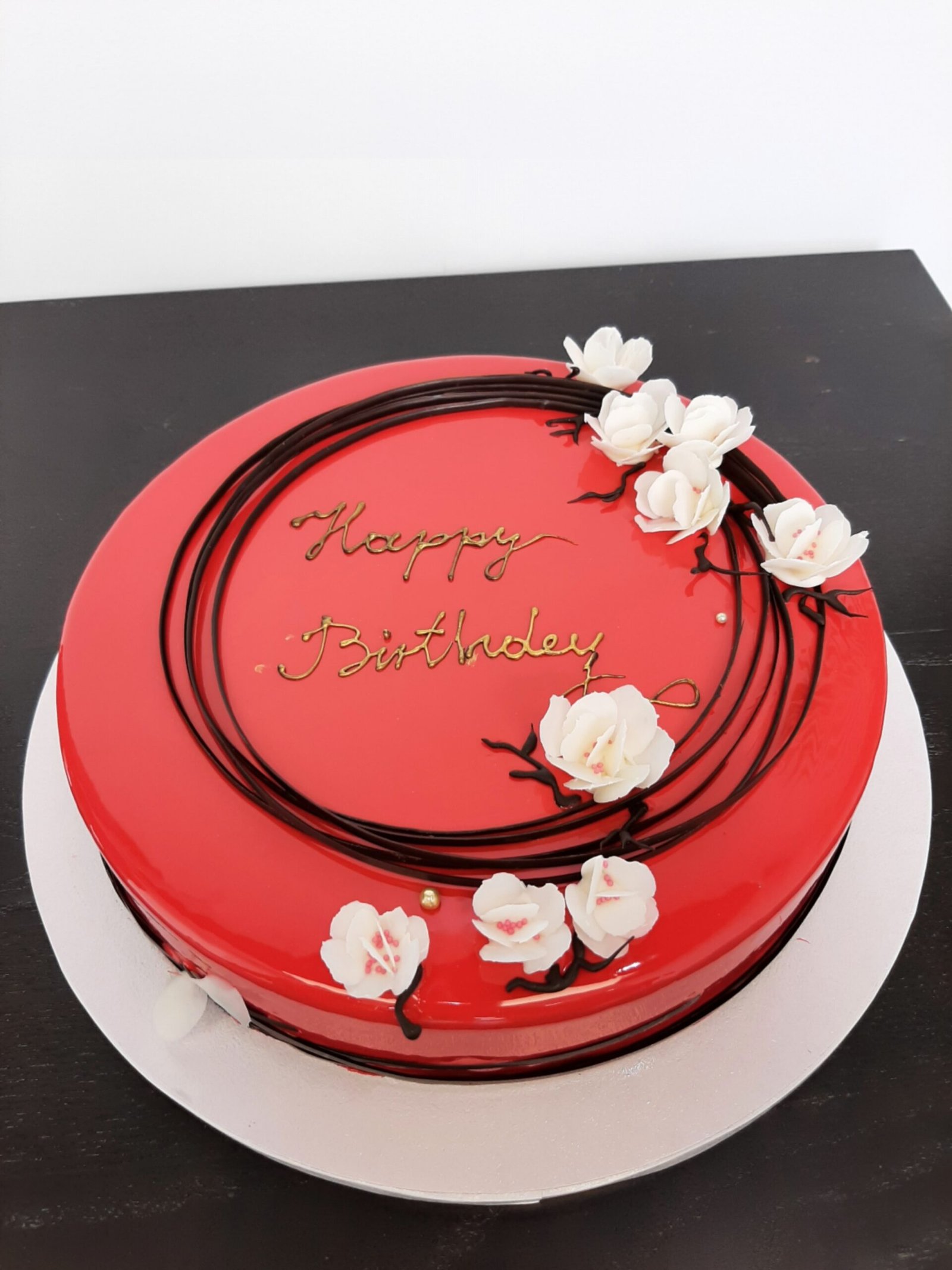 Tort czerwony „Happy Birthday" z kwiatami